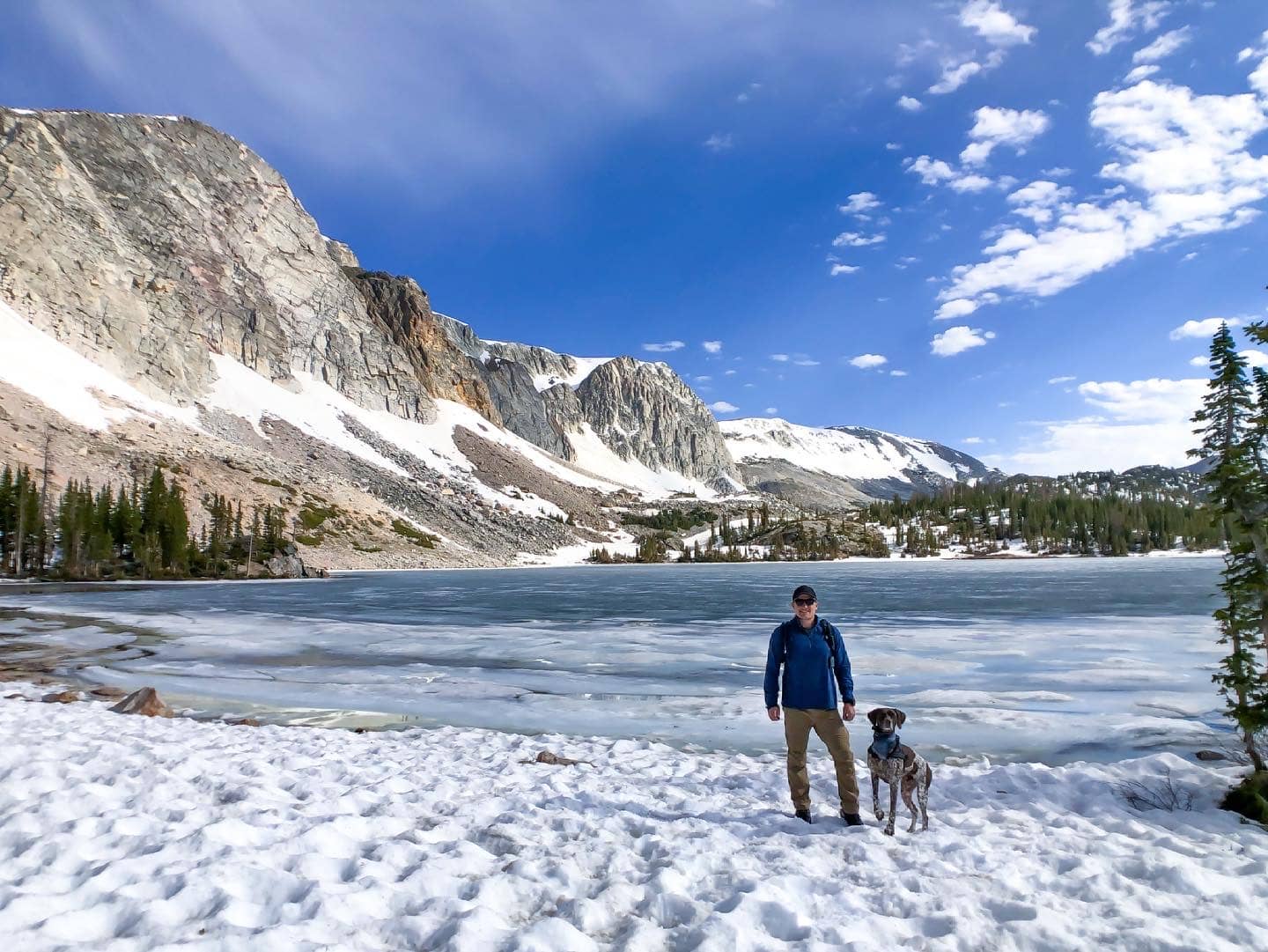 A man and dog standing near a lake at Medicine Bow-Routt National Forest